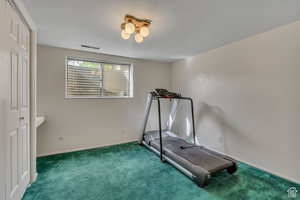 Exercise area with carpet floors and baseboards