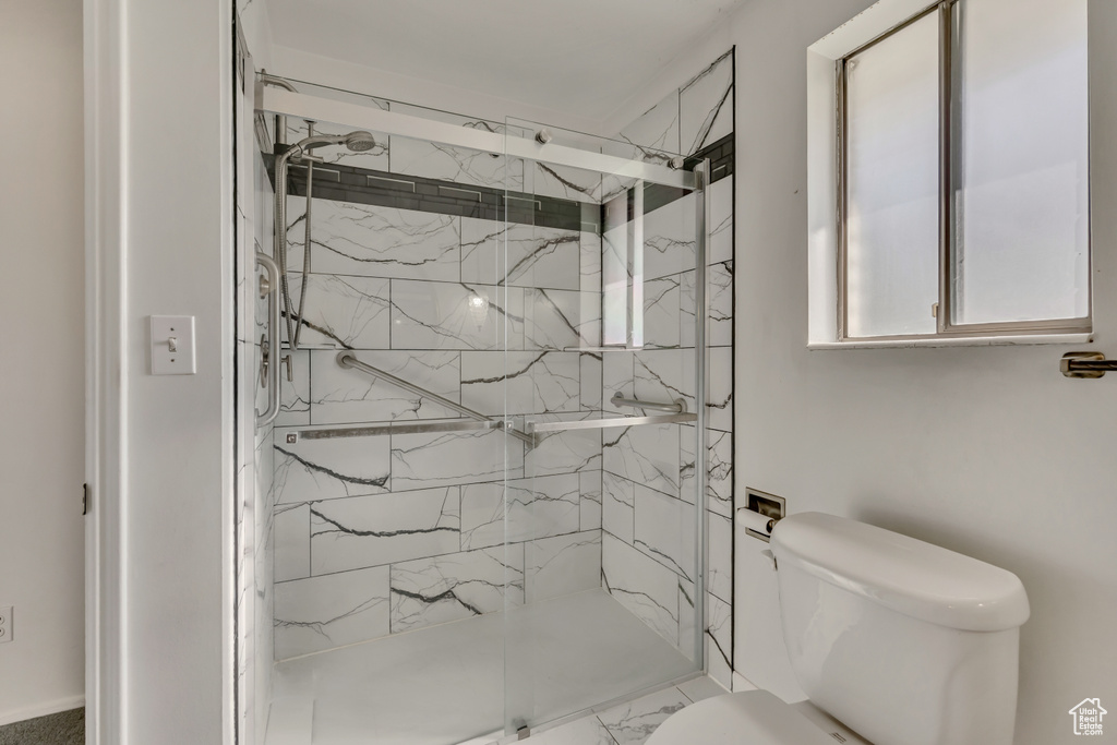 Bathroom with a marble finish shower and marble look tiles