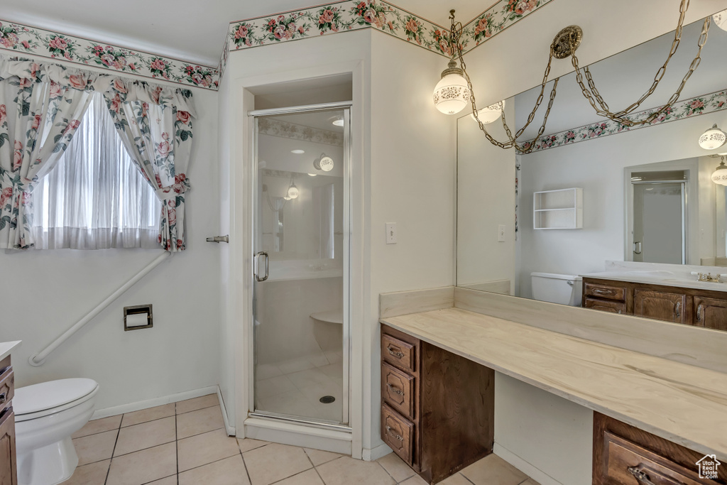 Bathroom featuring vanity, a shower stall, and tile patterned flooring