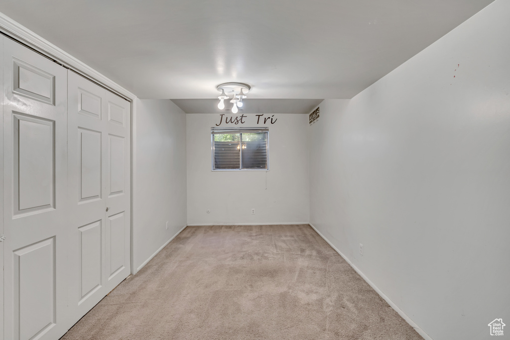 Spare room featuring light carpet and baseboards