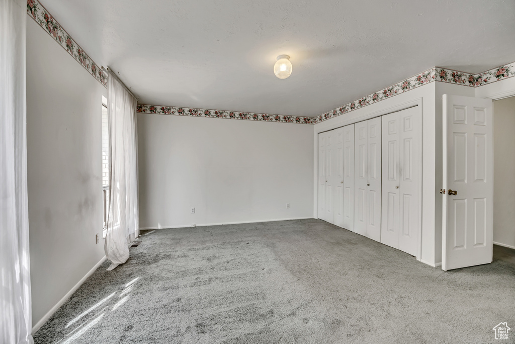 Unfurnished bedroom featuring carpet and a closet