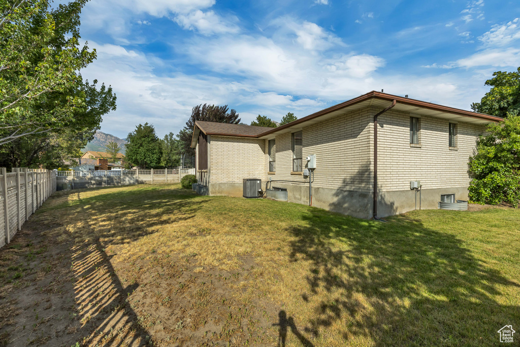 Rear view of property with a fenced backyard, a mountain view, and brick siding
