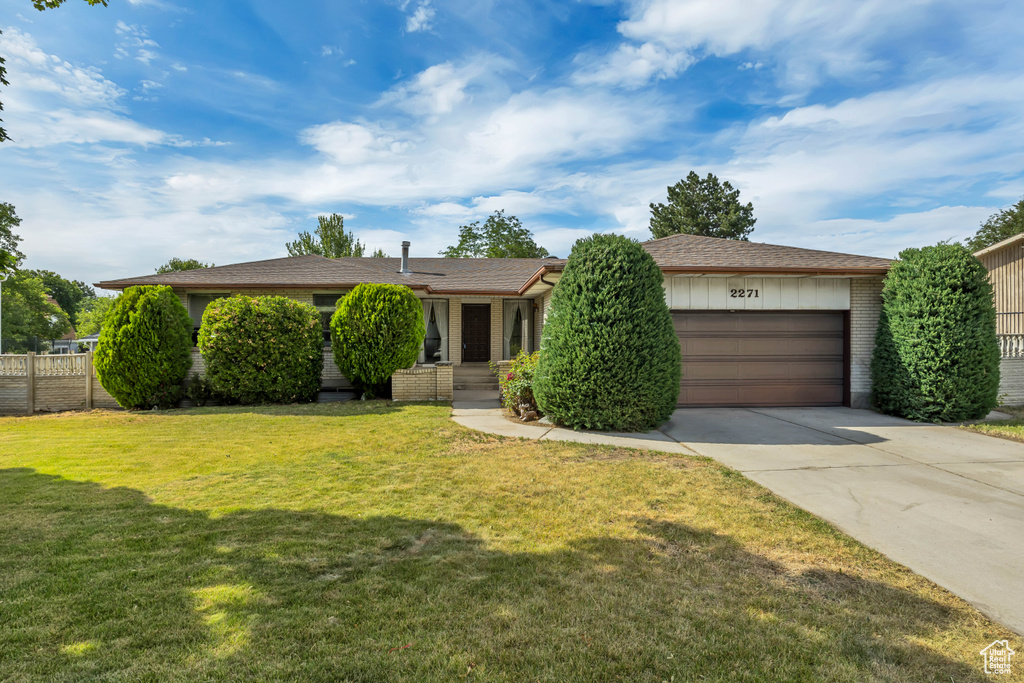 View of front facade featuring an attached garage, concrete driveway, and brick siding