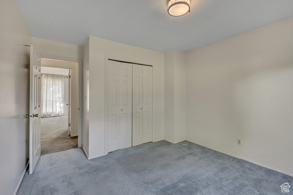 Unfurnished bedroom with carpet and a closet