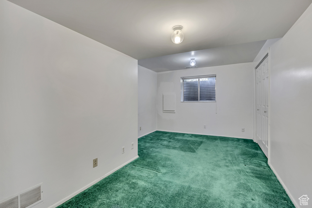 Carpeted empty room with baseboards