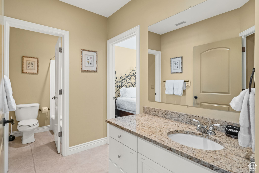 Ensuite bathroom featuring vanity and tile patterned floors