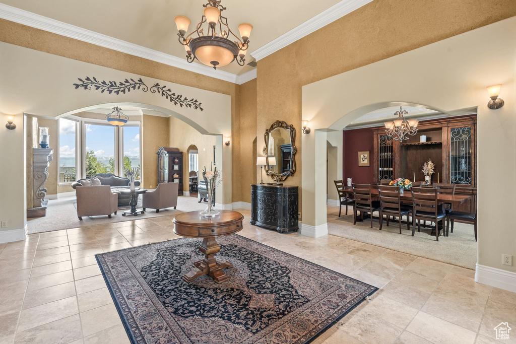 Entrance foyer featuring a chandelier, arched walkways, and ornamental molding