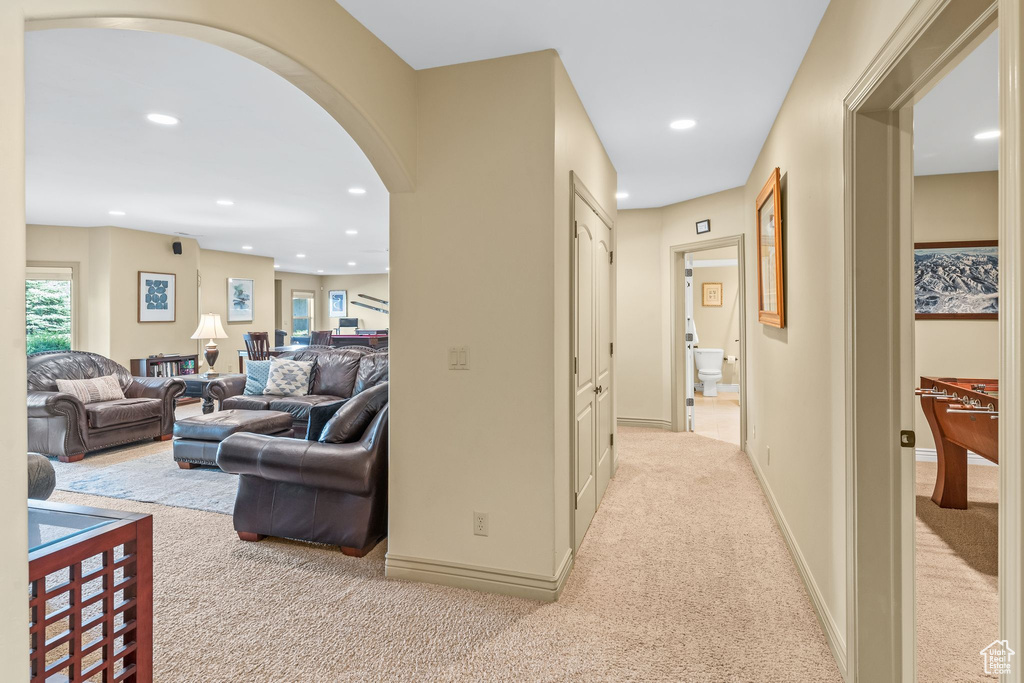 Hall featuring carpet floors, arched walkways, and recessed lighting
