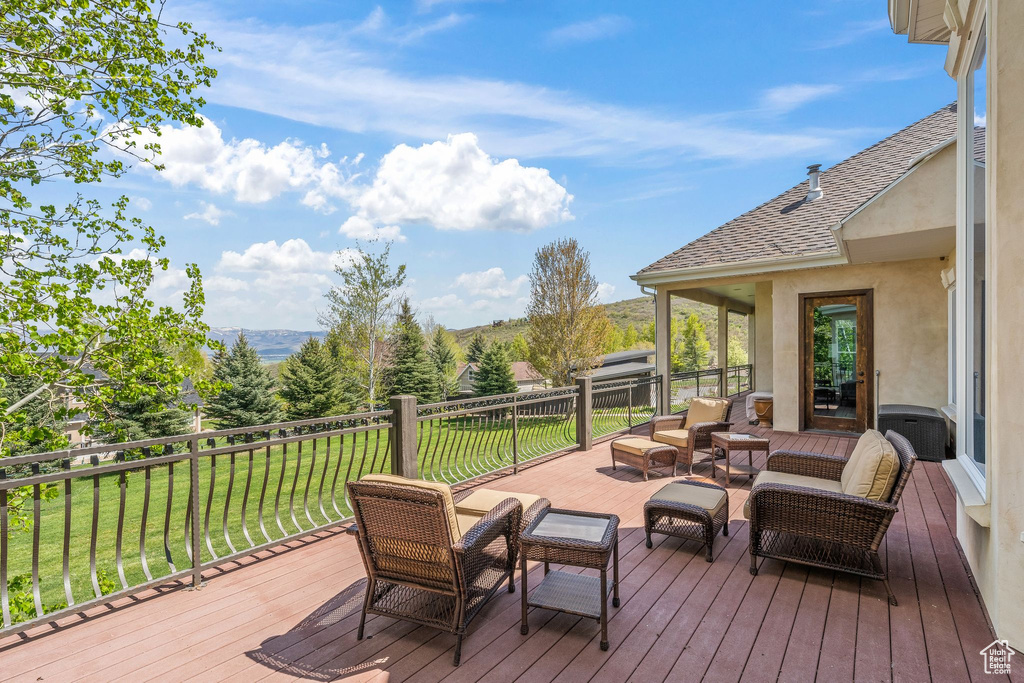 Deck with a lawn, a mountain view, and an outdoor living space