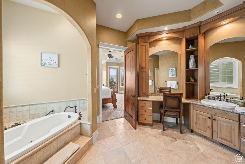 Bathroom featuring ensuite bath, a ceiling fan, vanity, and a bath
