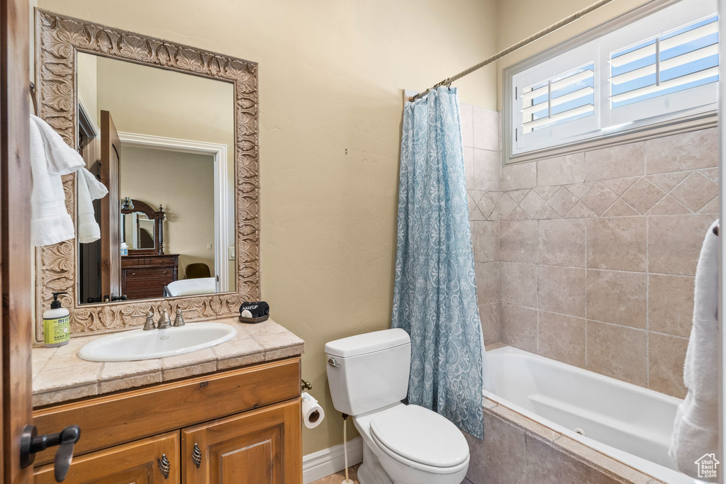 Bathroom with tiled shower / bath combo and vanity