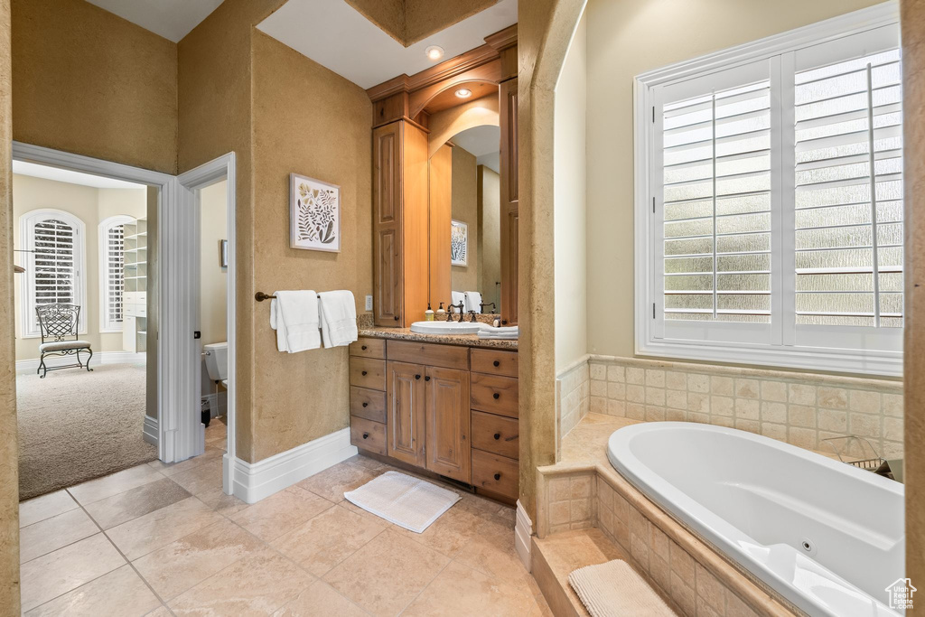 Full bathroom featuring a bath, vanity, and tile patterned floors