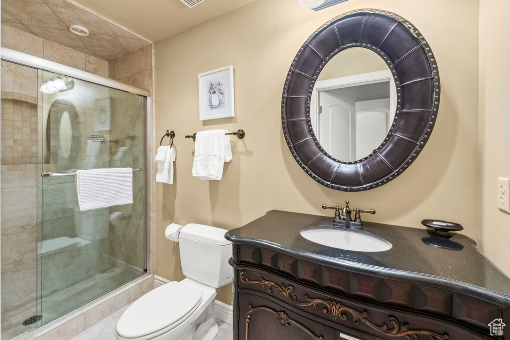 Bathroom with vanity, a tile shower, and tile patterned floors