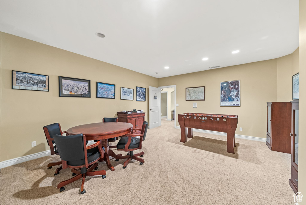 Recreation room with light colored carpet and recessed lighting