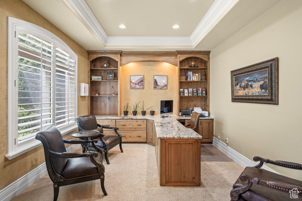 Home office with plenty of natural light, ornamental molding, a raised ceiling, and built in features