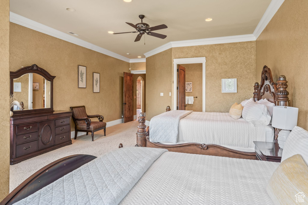 Carpeted bedroom with ornamental molding, recessed lighting, arched walkways, and ceiling fan