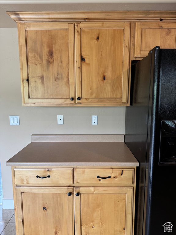 Kitchen featuring black fridge and light tile patterned floors