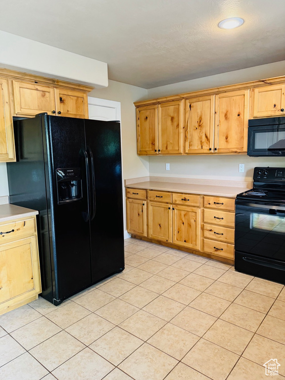 Kitchen featuring black appliances, light countertops, and light tile patterned floors