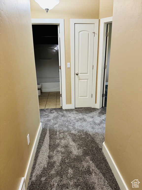 Hall featuring carpet floors and tile patterned flooring