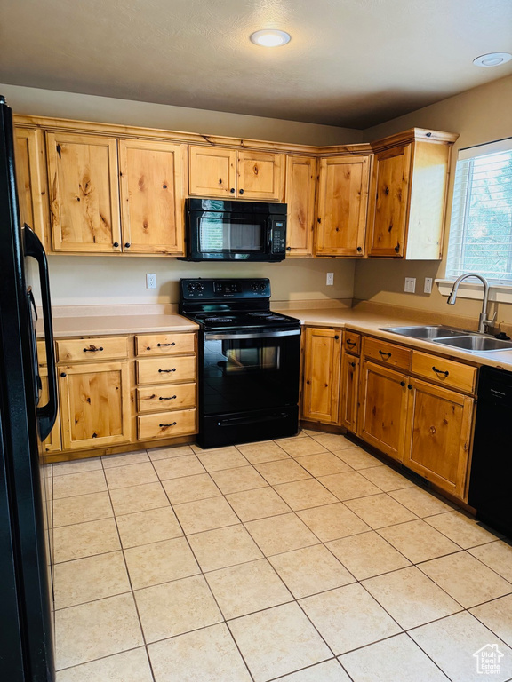 Kitchen featuring black appliances, light countertops, light tile patterned floors, and recessed lighting