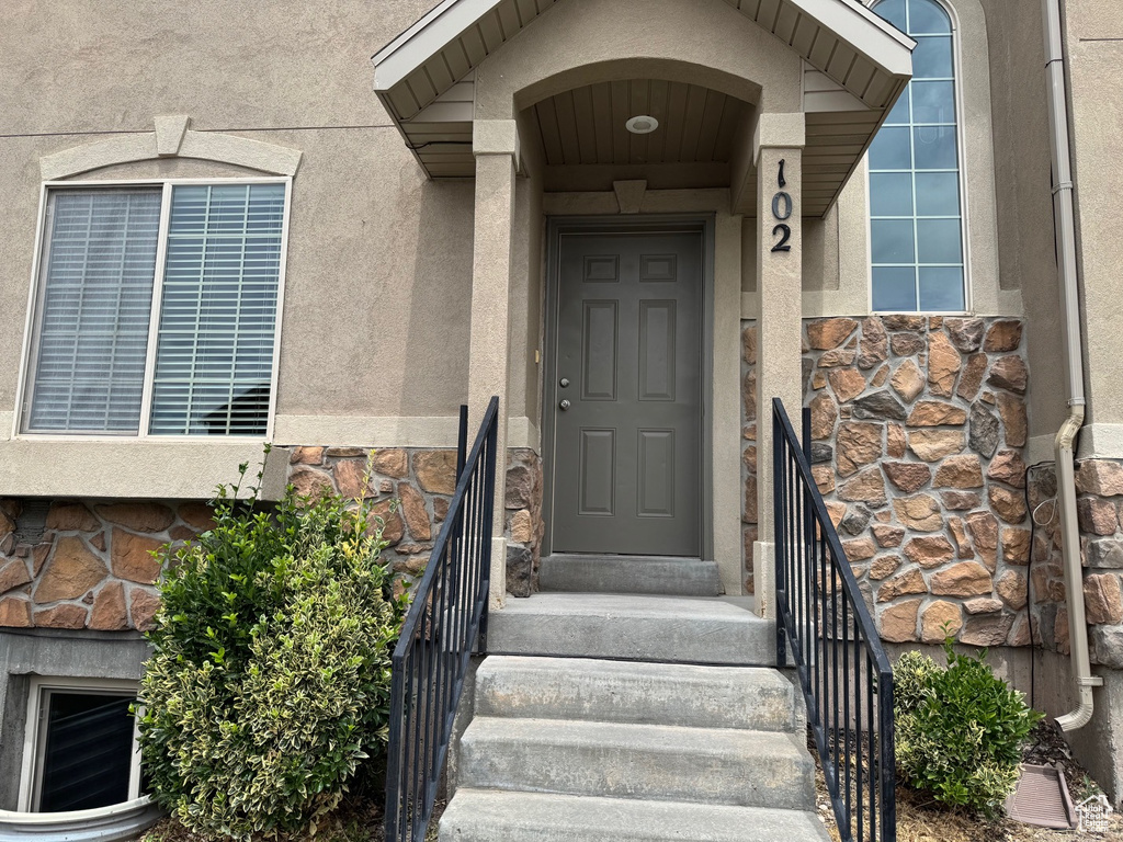 Property entrance featuring stone siding and stucco siding