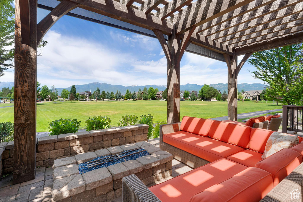 View of patio featuring an outdoor living space with a fire pit, a mountain view, a pergola, and golf course view