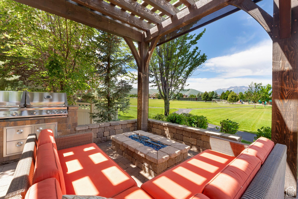 View of patio featuring a mountain view, a fire pit, a pergola, and area for grilling