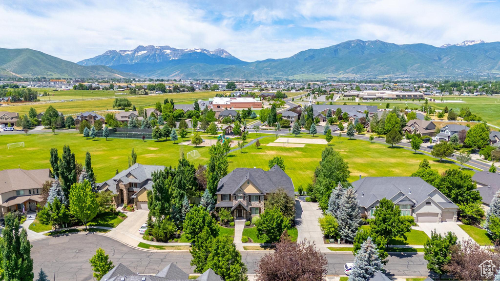 Aerial perspective of suburban area featuring a mountainous background and a golf club