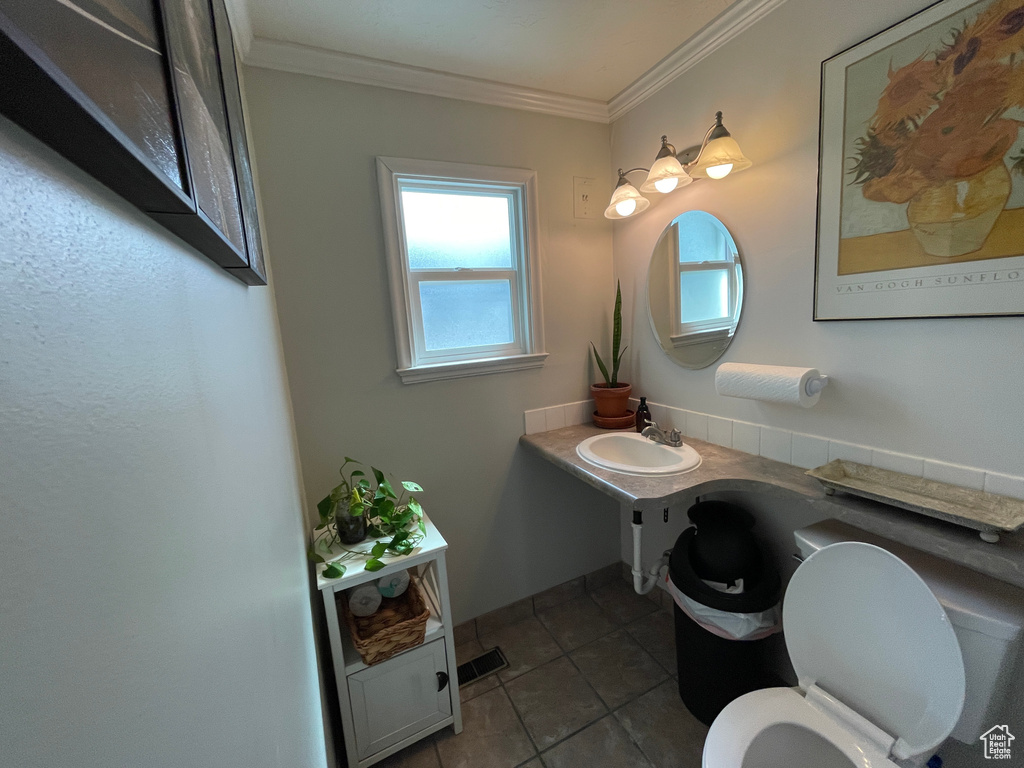 Bathroom with crown molding, tile patterned flooring, and vanity