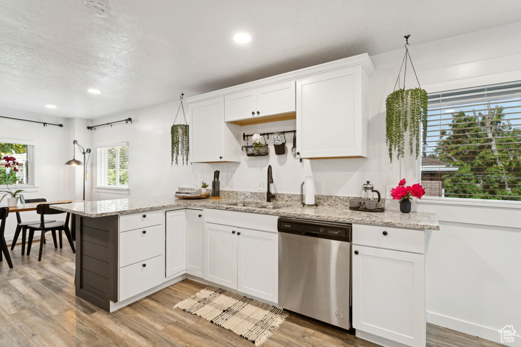 Kitchen featuring stainless steel dishwasher, light wood-style floors, white cabinetry, a peninsula, and recessed lighting