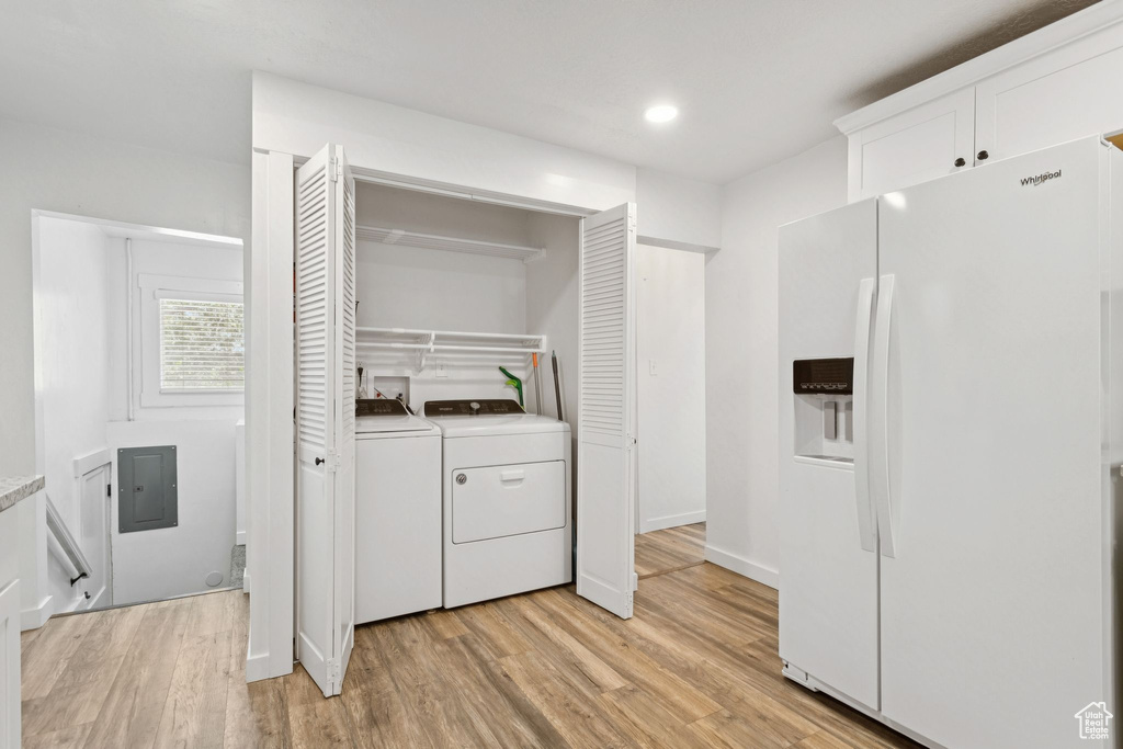 Laundry area with washer and clothes dryer, light wood-style flooring, electric panel, and recessed lighting