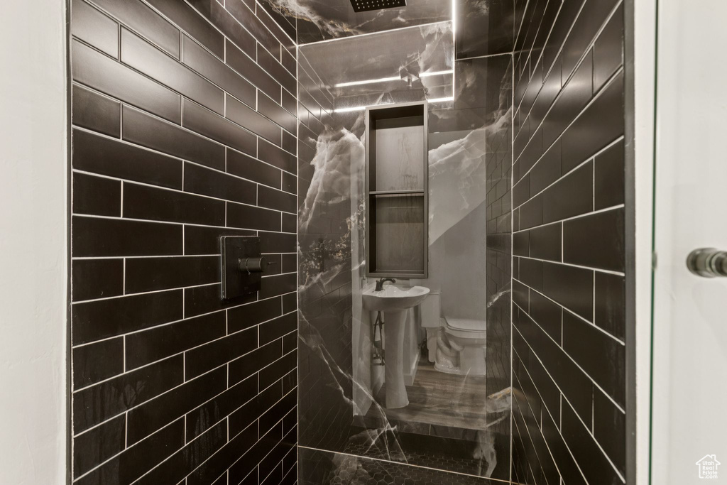 Full bathroom with tiled shower and marble finish floors