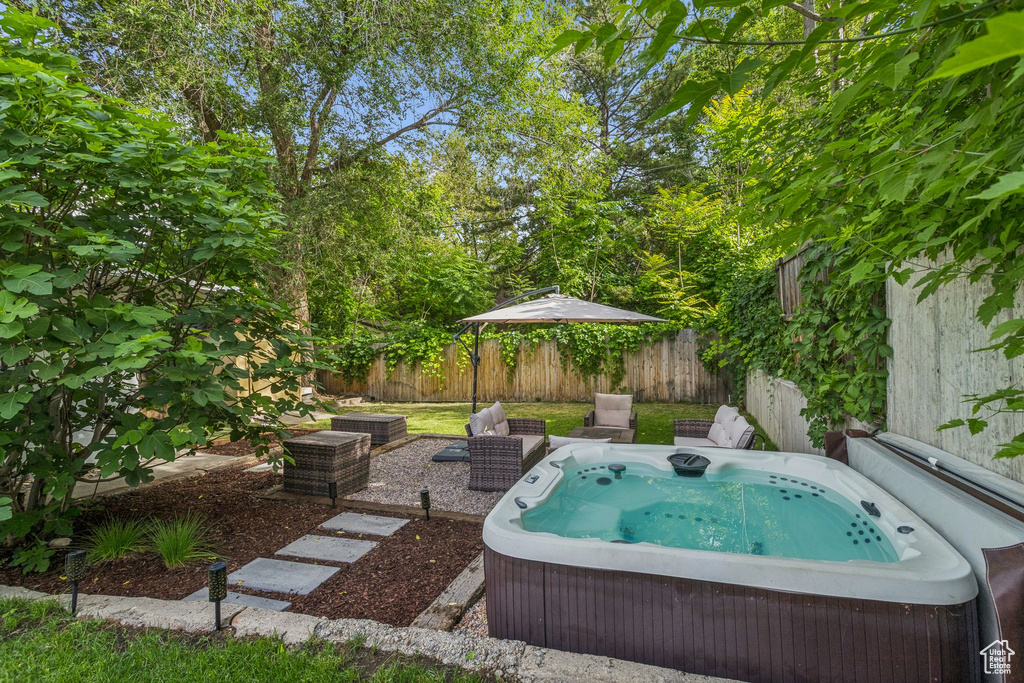 View of swimming pool featuring a hot tub and a fenced backyard