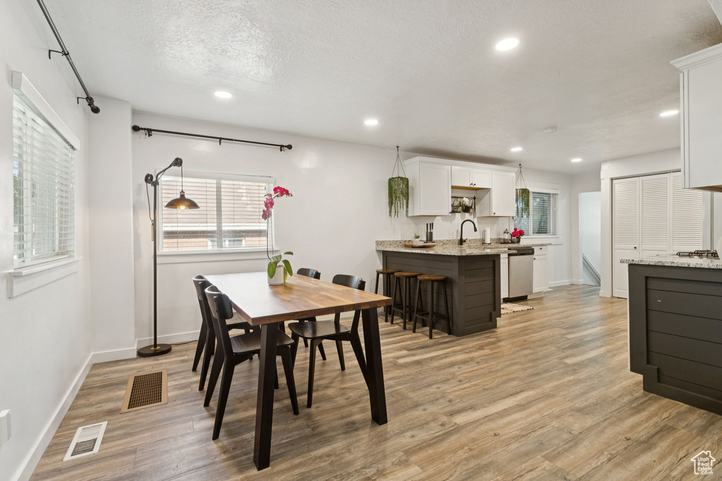 Dining room with light wood finished floors, plenty of natural light, and recessed lighting