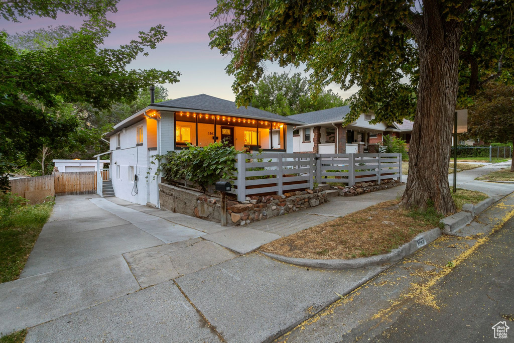 View of front of property featuring a fenced front yard, driveway, and covered porch