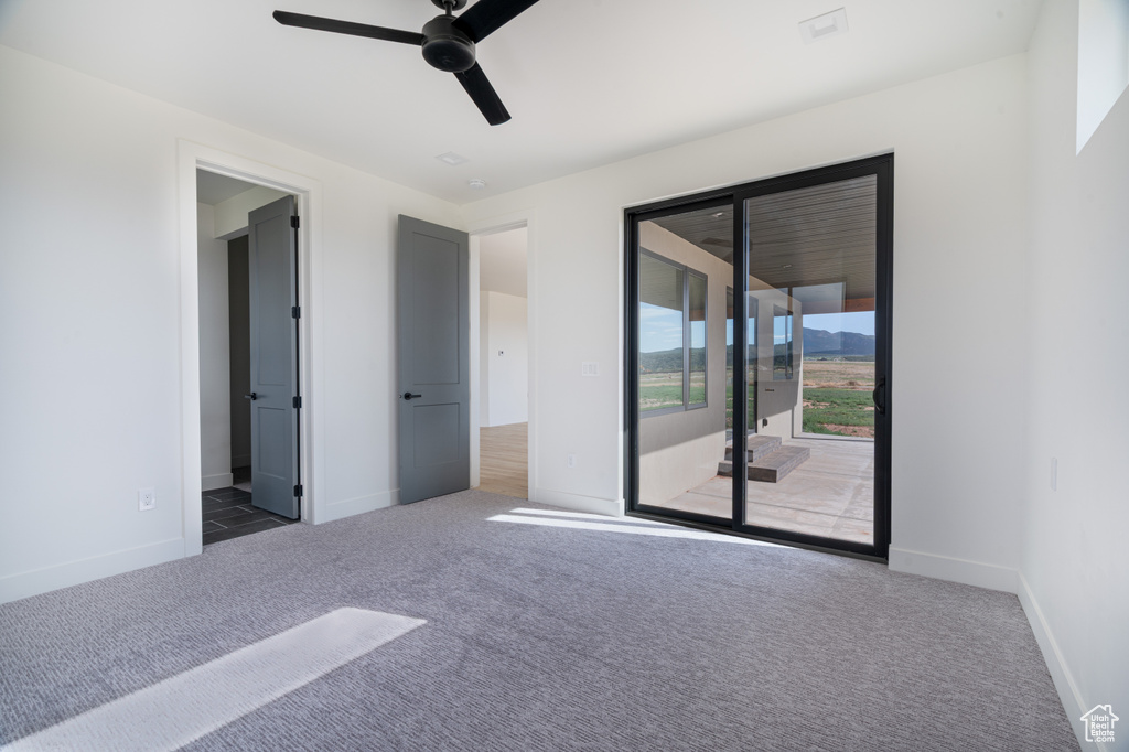 Unfurnished bedroom with access to exterior, carpet, and ceiling fan