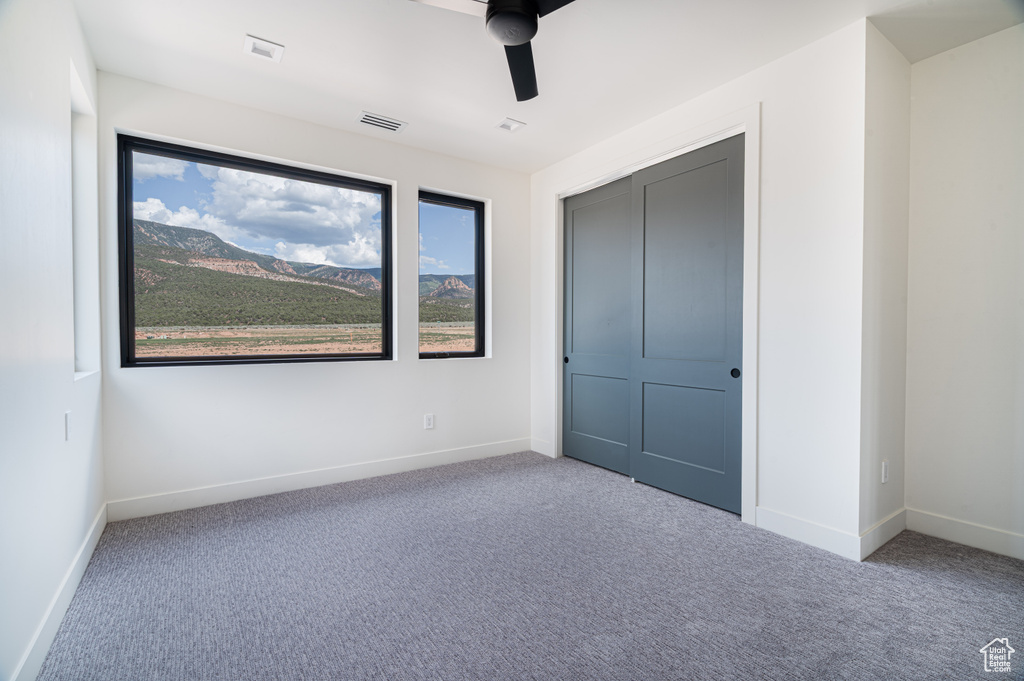 Unfurnished bedroom with carpet floors, a ceiling fan, and a closet