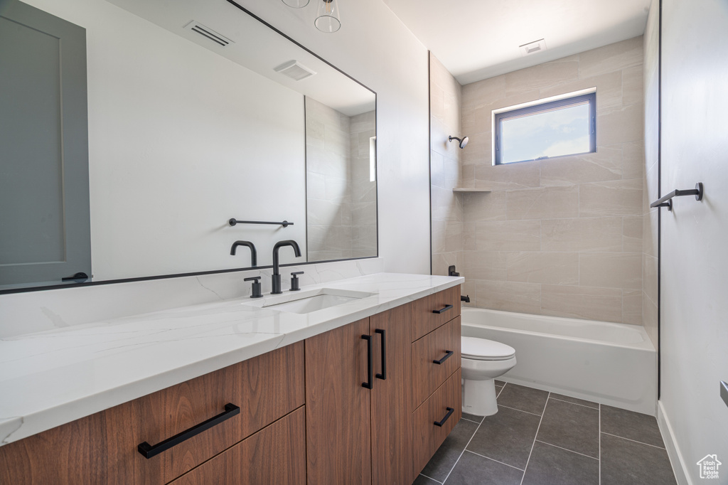 Bathroom featuring vanity, tile patterned floors, and tub / shower combination