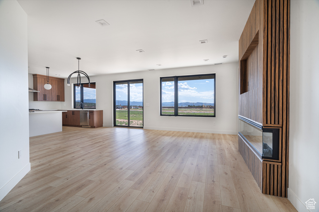 Unfurnished living room featuring light wood-style floors and baseboards