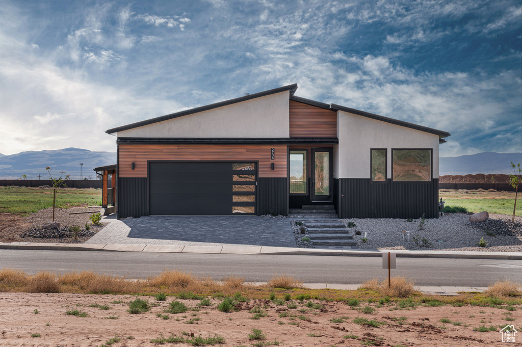 Contemporary house with a mountain view, a garage, and decorative driveway
