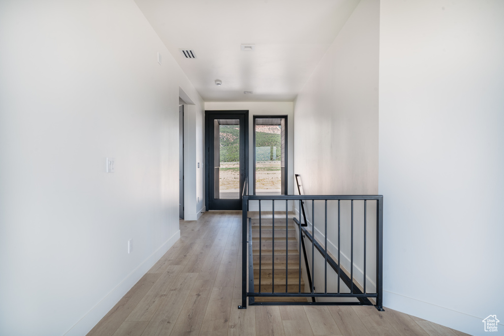Foyer entrance with light wood finished floors and baseboards