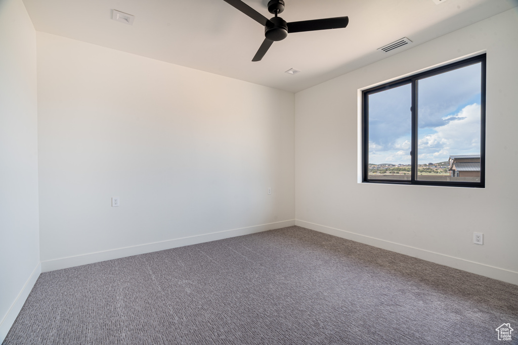 Empty room featuring ceiling fan and carpet