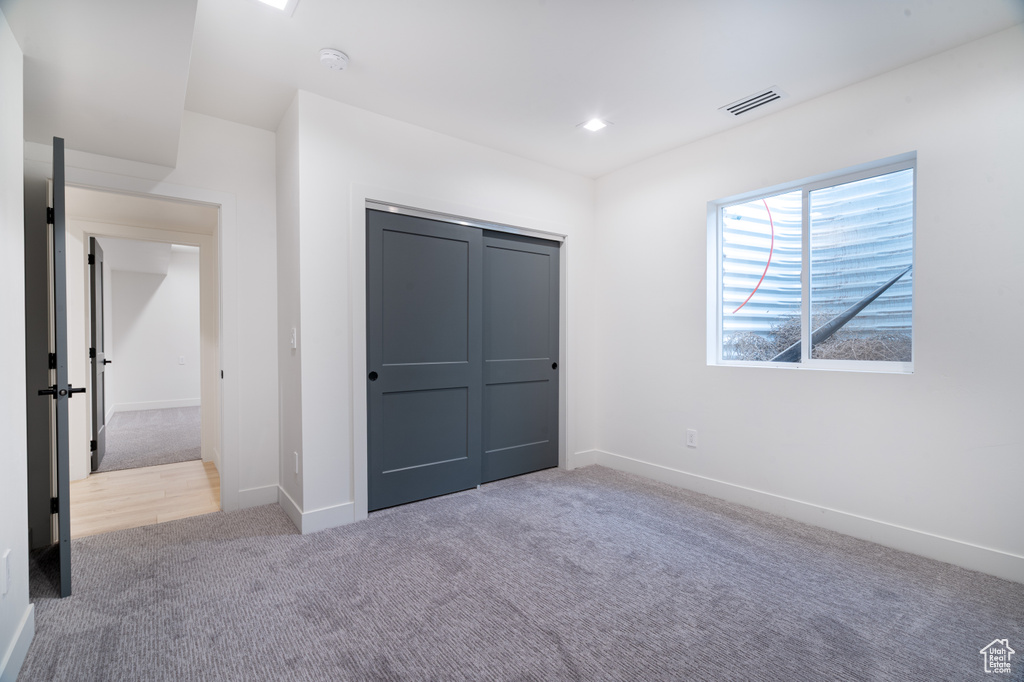 Unfurnished bedroom featuring carpet flooring, a closet, and recessed lighting