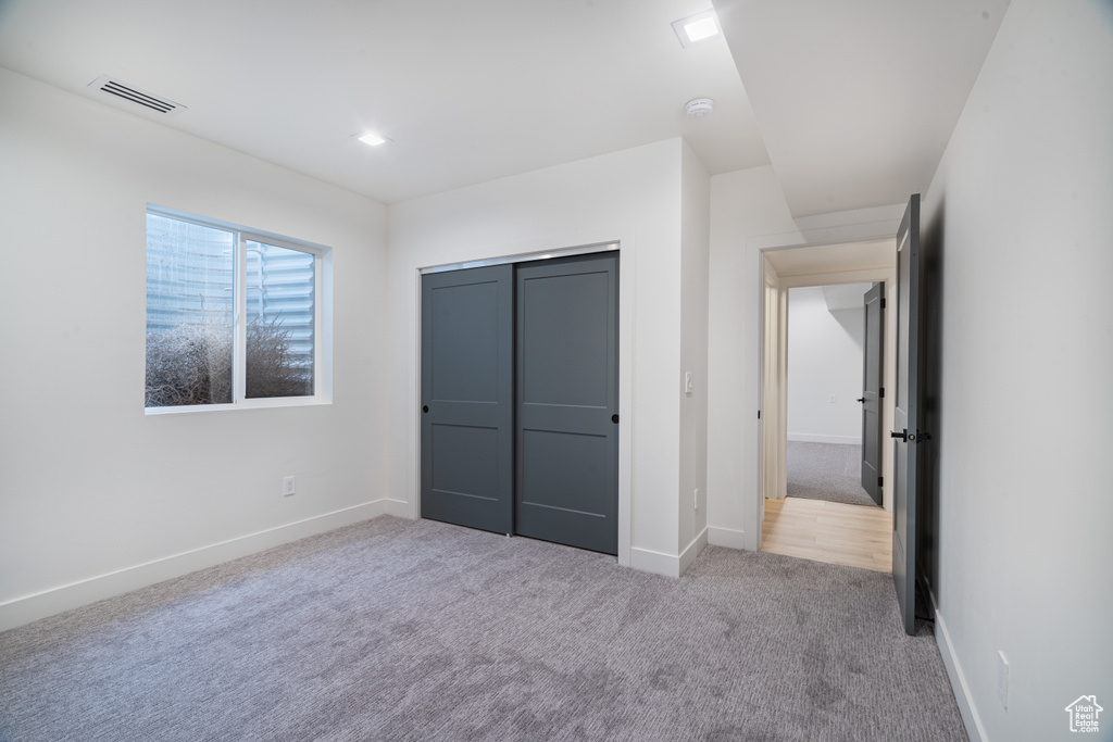 Unfurnished bedroom with carpet and a closet