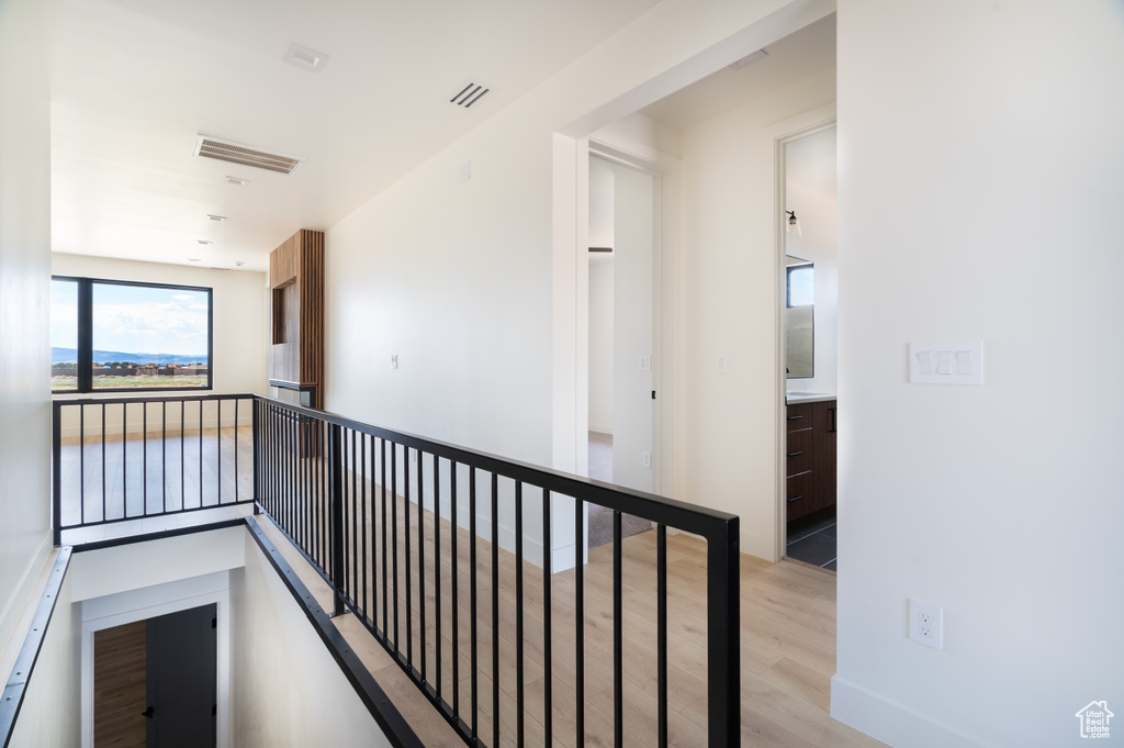 Hall featuring light wood finished floors and an upstairs landing