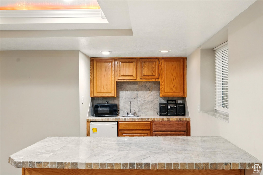 Kitchen with black microwave, dishwasher, tasteful backsplash, light countertops, and recessed lighting