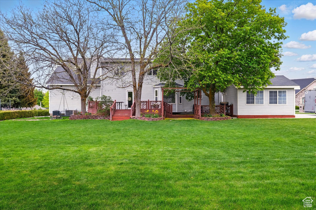 View of grassy yard with a deck