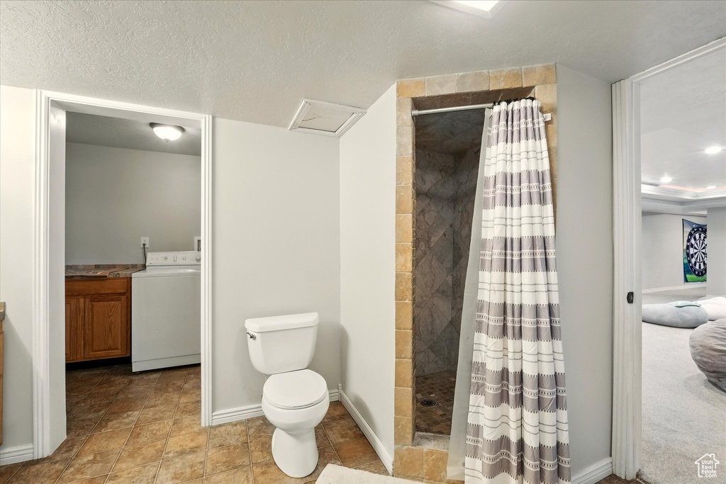 Bathroom featuring washer / dryer, tiled shower, and vanity