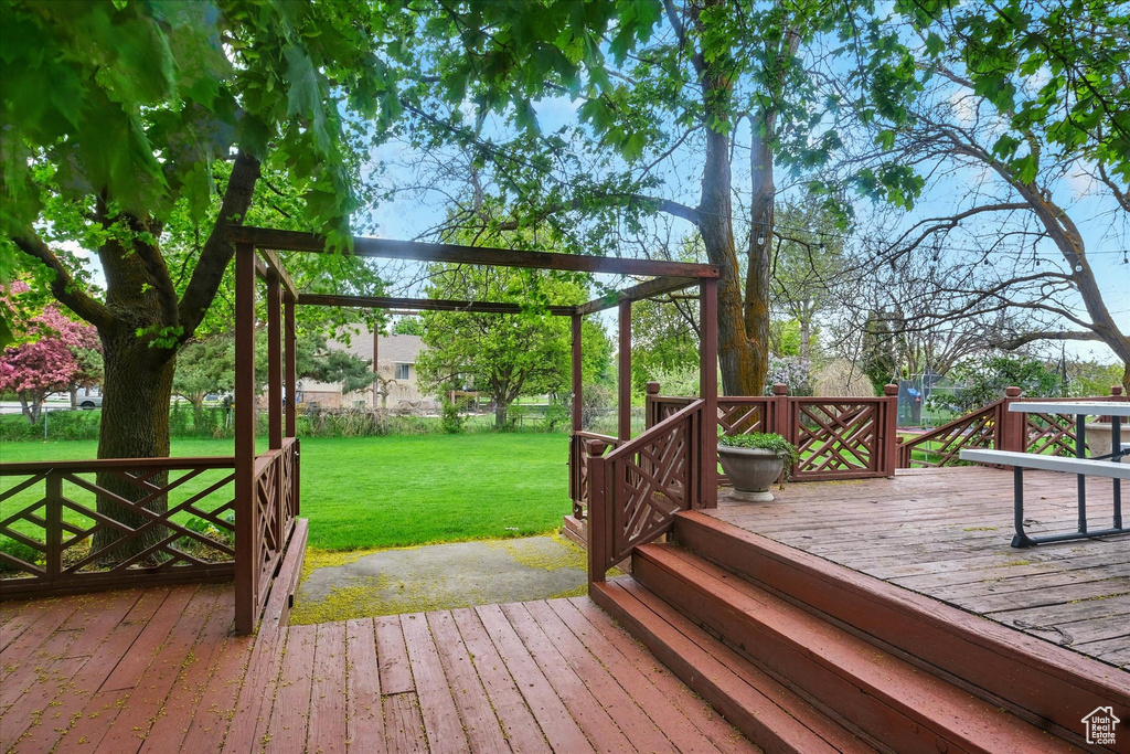 Wooden terrace featuring a yard