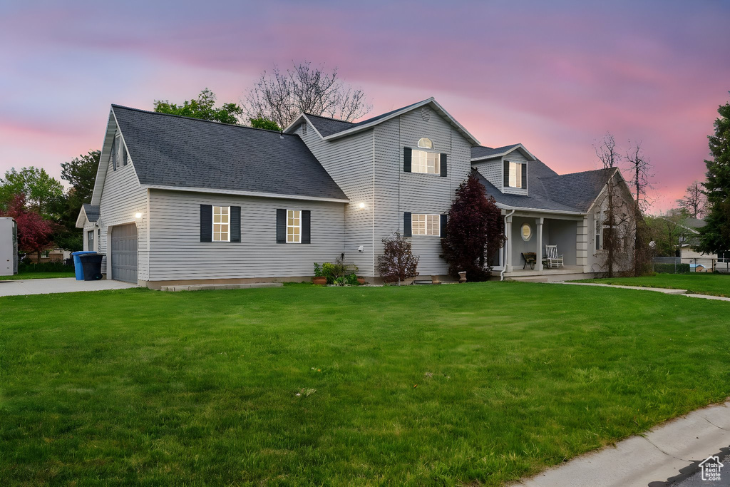 Traditional home with a porch, a front lawn, concrete driveway, and a shingled roof